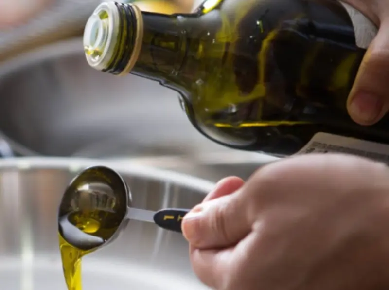 olio extra vergine d'oliva in un cucchiaio per dosare il condimento