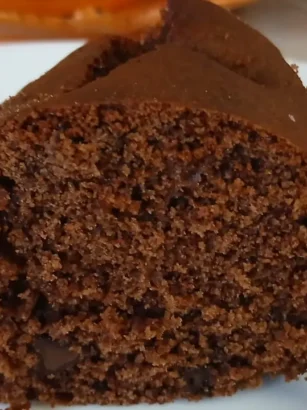 Fetta di ciambellone al cacao soffice senza burro né olio con pezzi di cioccolato fondente e forchettina