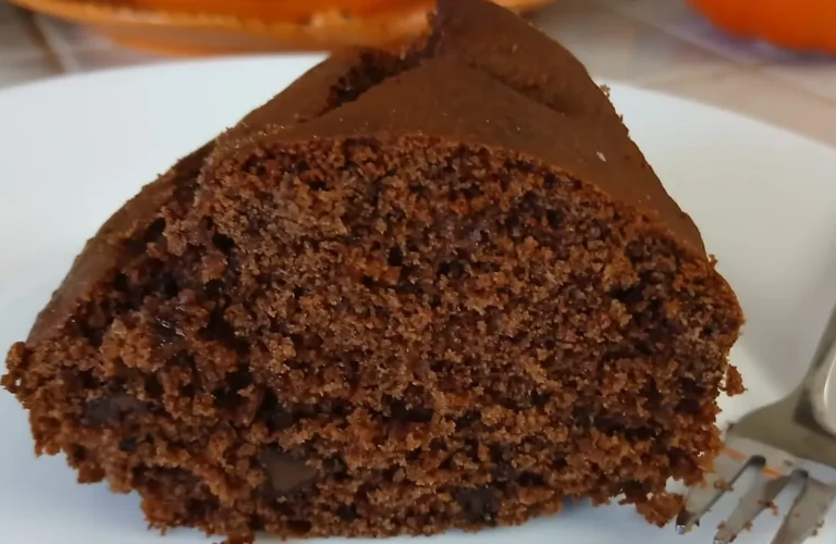 Fetta di ciambellone al cacao soffice senza burro né olio con pezzi di cioccolato fondente e forchettina