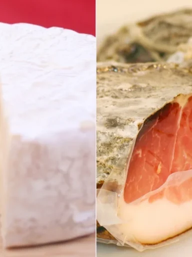 Primo piano di una forma di formaggio Brie tagliata e di un pezzo di speck stagionato.
