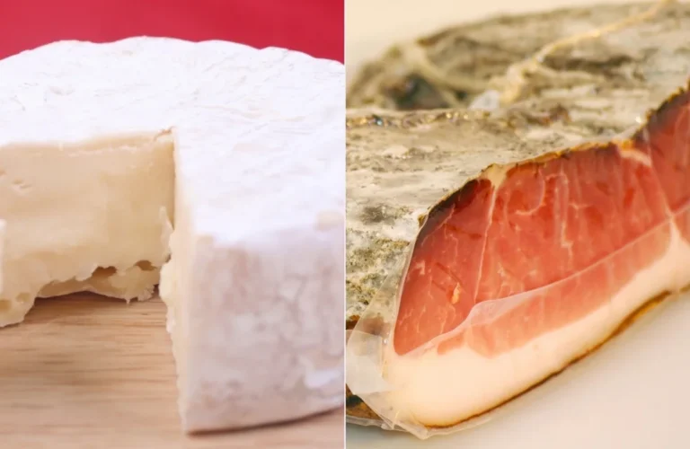 Primo piano di una forma di formaggio Brie tagliata e di un pezzo di speck stagionato.