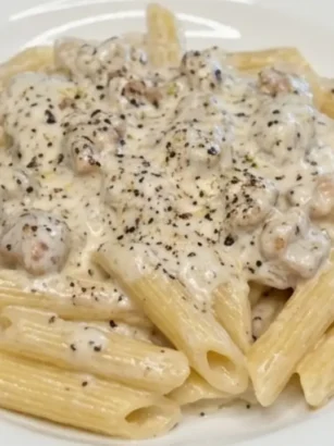 Piatto di penne alla norcina cremosi con salsiccia sgranata e pecorino