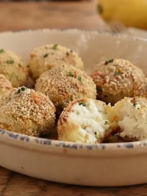 Polpette di ricotta al limone dorate e croccanti servite in una pirofila di ceramica
