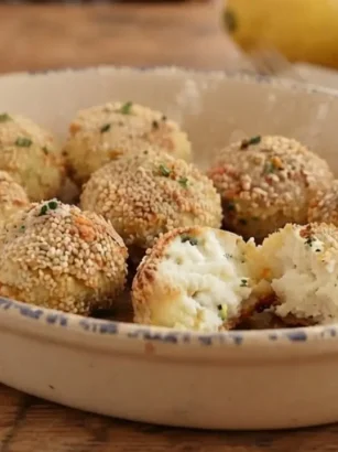 Polpette di ricotta al limone dorate e croccanti servite in una pirofila di ceramica