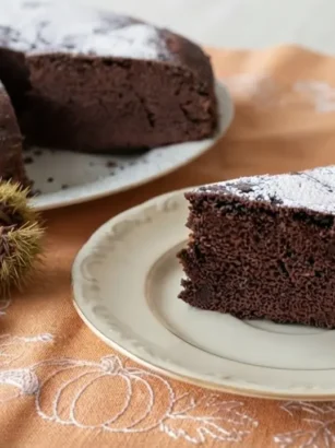 Torta di castagne e cioccolato senza burro marrone scuro e spumosa con zucchero a velo