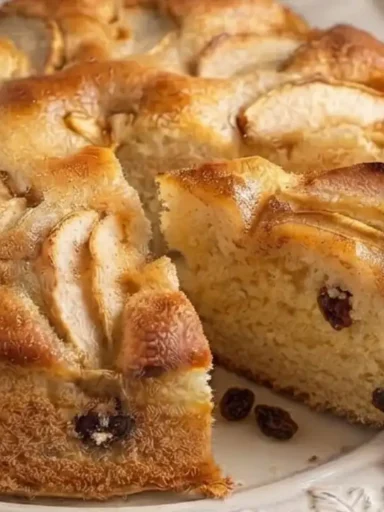 Fetta di torta di mele francescana alta e soffice con uvetta e crosticina caramellata di zucchero e burro