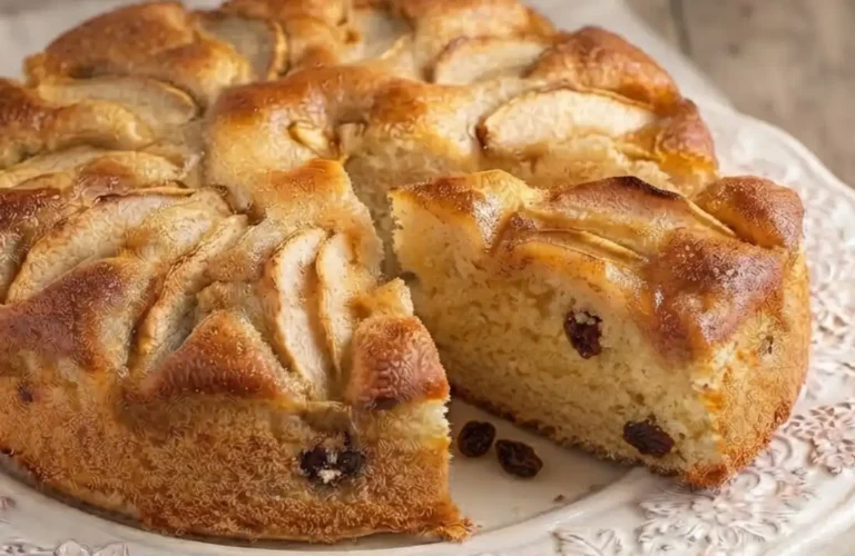 Fetta di torta di mele francescana alta e soffice con uvetta e crosticina caramellata di zucchero e burro